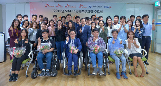 21일 서울 중구 한국장애인고용공단 서울맞춤훈련센터에서 열린 '씨앗2.0' 프로그램 3기 수료식에서 수료생들과 관계자들이 사진을 찍고 있다.  SK㈜ C&C 제공